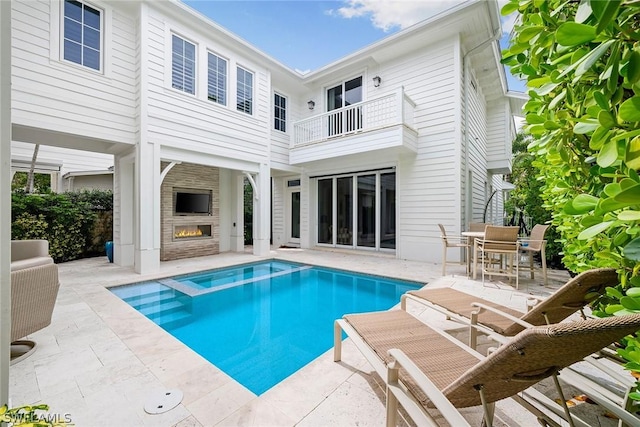 view of pool with a patio and an outdoor fireplace