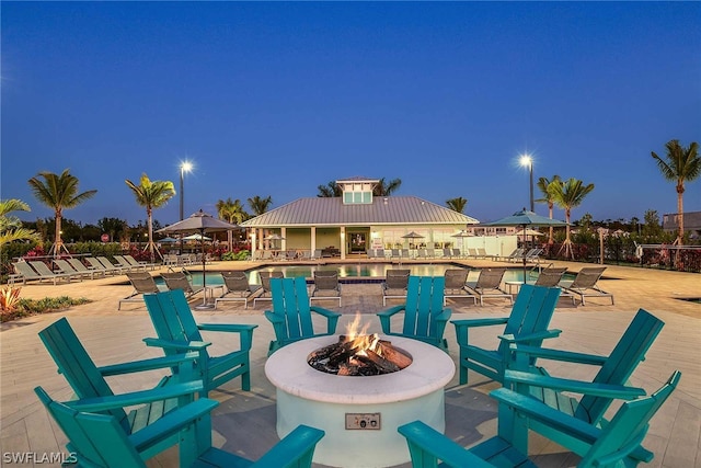 view of patio with a community pool and a fire pit