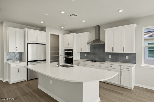 kitchen featuring visible vents, freestanding refrigerator, double oven, wall chimney exhaust hood, and black electric stovetop