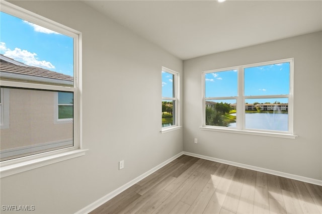 empty room with baseboards and light wood finished floors