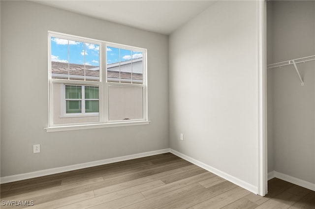 unfurnished bedroom featuring a closet, baseboards, and wood finished floors