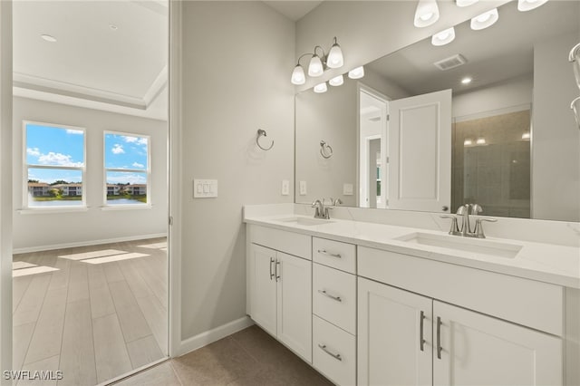 full bath with a sink, visible vents, double vanity, and a tile shower