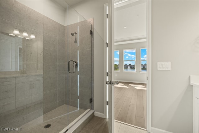 full bath with a stall shower, baseboards, and wood finished floors