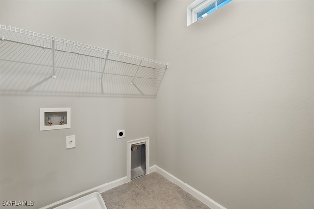 washroom with baseboards, washer hookup, laundry area, light tile patterned flooring, and hookup for an electric dryer