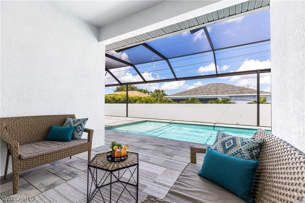 view of swimming pool with a lanai, outdoor lounge area, and a patio