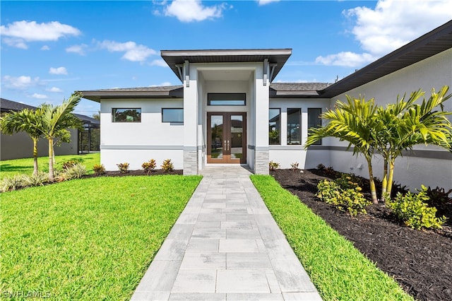 entrance to property featuring a yard and french doors