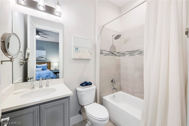 full bathroom with ceiling fan, vanity, shower / bath combo, and toilet