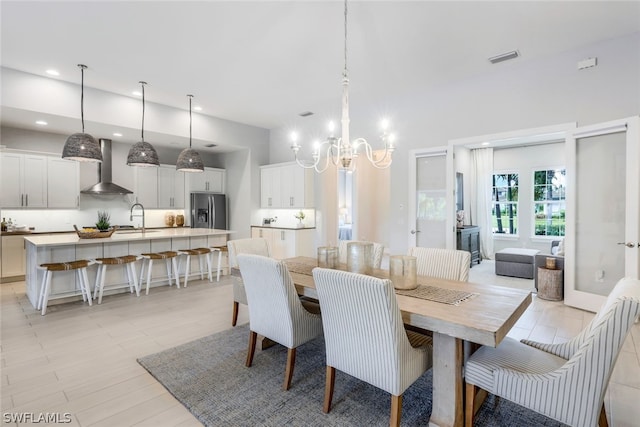 dining room with light hardwood / wood-style floors, a notable chandelier, and sink