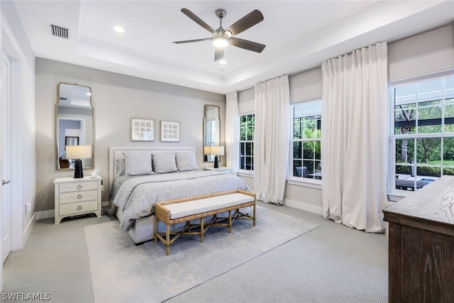 carpeted bedroom featuring a raised ceiling and ceiling fan