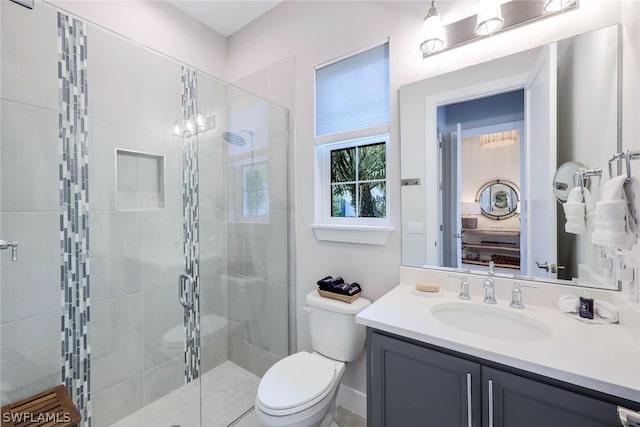 bathroom featuring vanity, toilet, and a shower with shower door