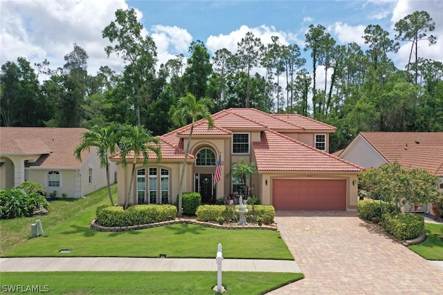 mediterranean / spanish-style house featuring a garage and a front lawn