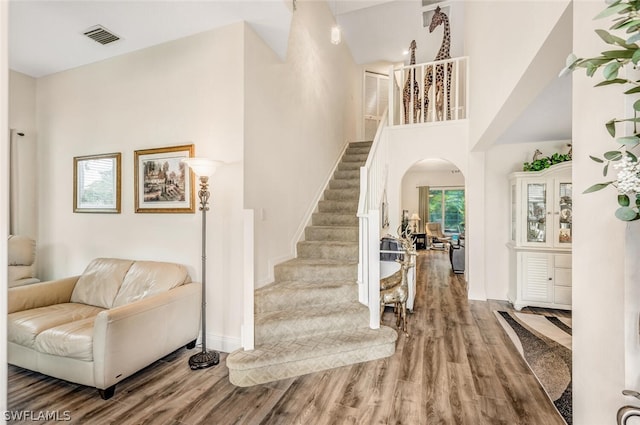 foyer featuring wood-type flooring and a high ceiling