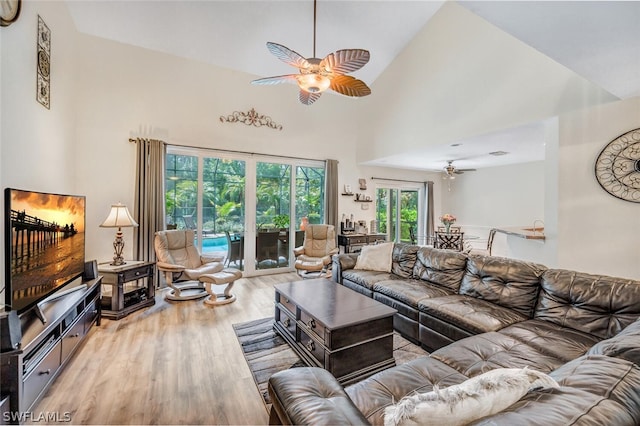 living room featuring light hardwood / wood-style floors, a healthy amount of sunlight, and high vaulted ceiling