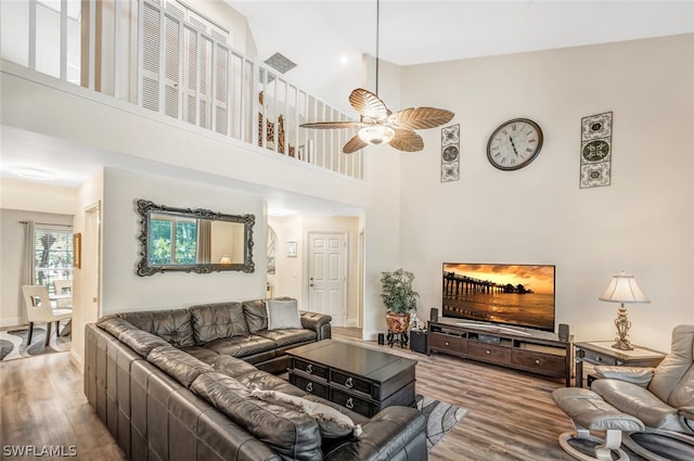 living room featuring wood-type flooring, high vaulted ceiling, and ceiling fan