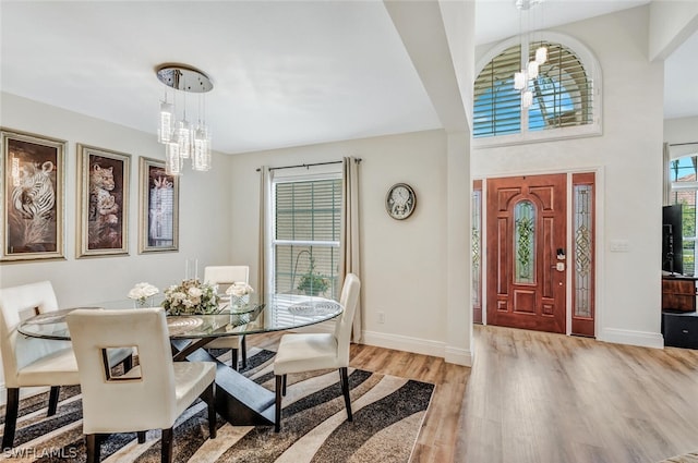 dining area with light hardwood / wood-style flooring and an inviting chandelier