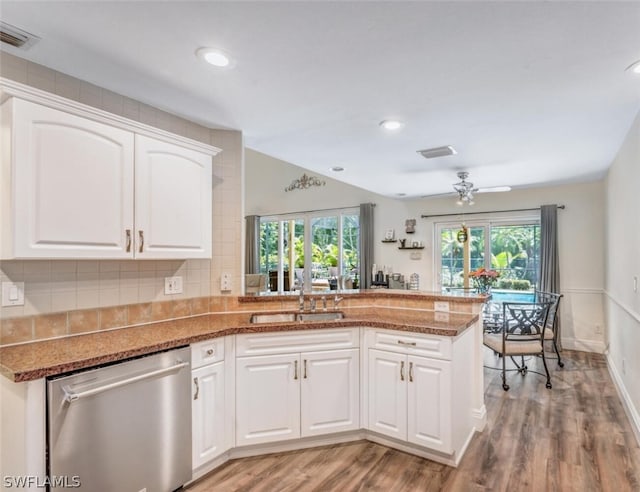 kitchen featuring kitchen peninsula, sink, white cabinets, and stainless steel dishwasher