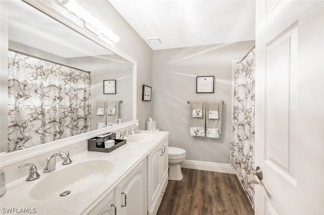 bathroom with hardwood / wood-style floors, vanity, and toilet