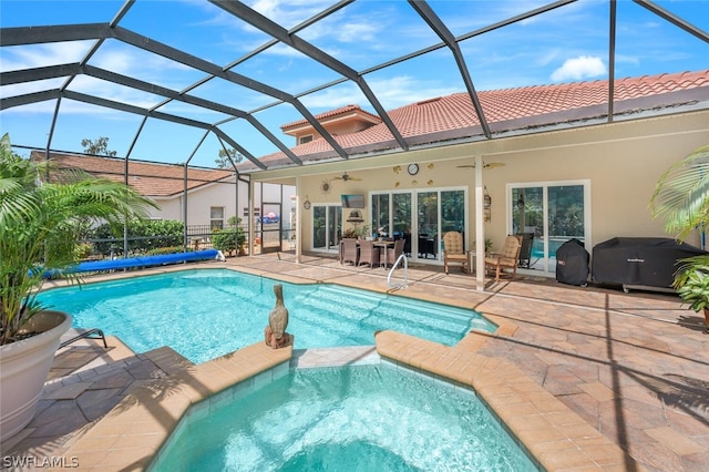 view of swimming pool with a patio, glass enclosure, and ceiling fan