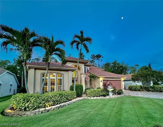 mediterranean / spanish-style home with a front yard and a garage