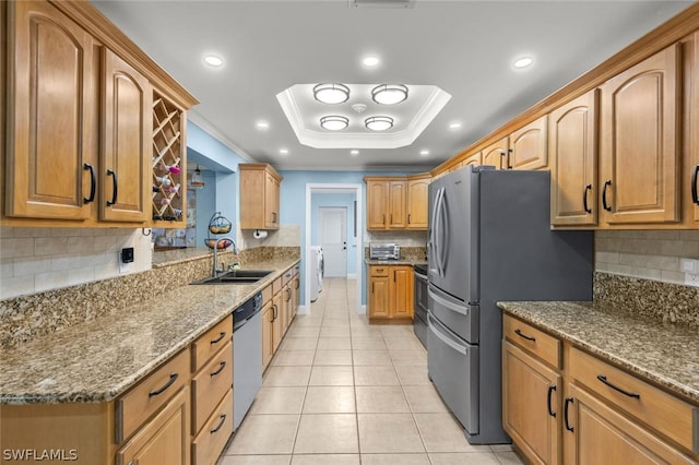 kitchen with stainless steel appliances, a raised ceiling, ornamental molding, and sink