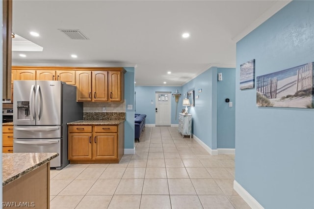 kitchen featuring tasteful backsplash, ornamental molding, light tile patterned floors, stone countertops, and stainless steel fridge with ice dispenser