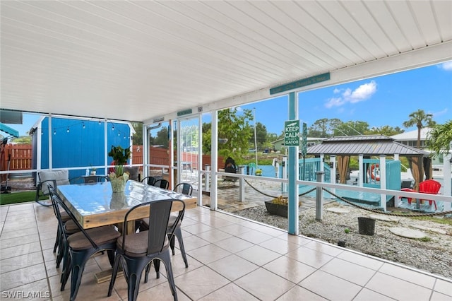 sunroom featuring a water view