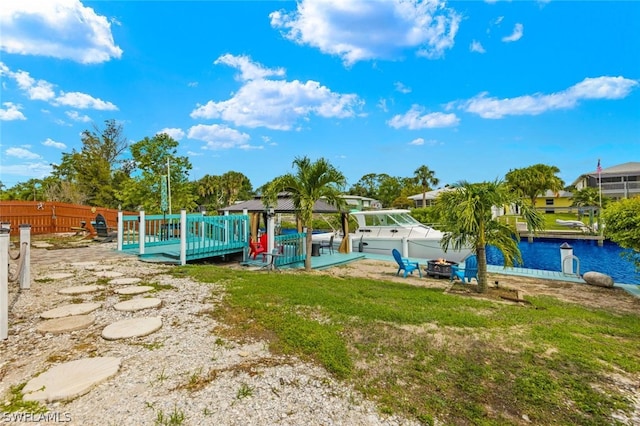 view of playground with a yard, a deck with water view, and a boat dock