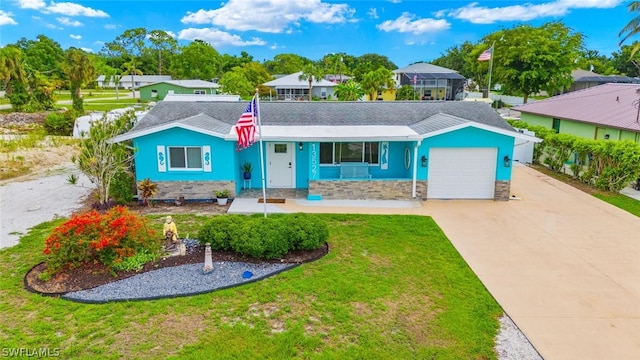 view of front of property featuring a porch, a garage, and a front lawn