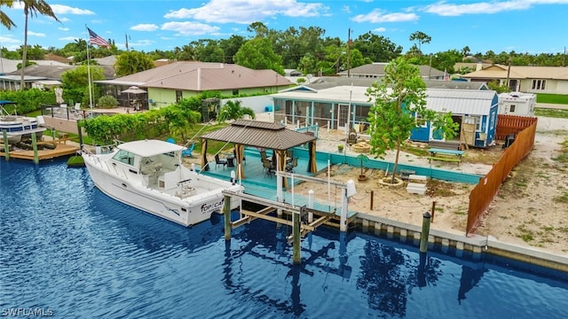 view of pool with a sunroom, a boat dock, and a water view