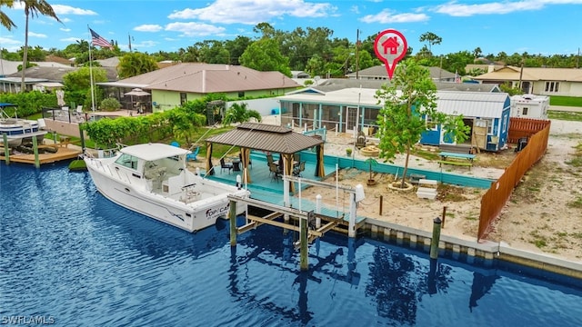 view of pool with a water view, a dock, and a sunroom