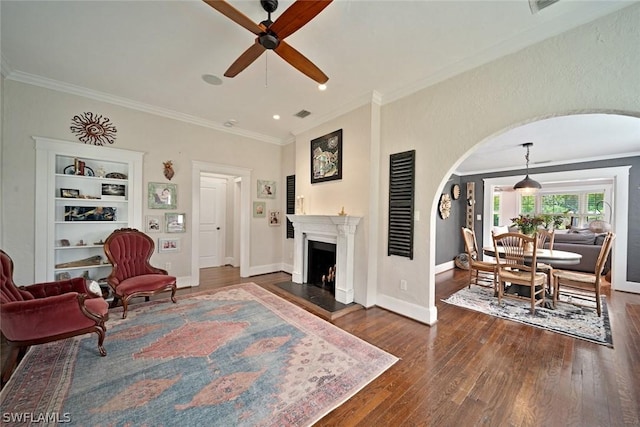 living room with ceiling fan, crown molding, and dark hardwood / wood-style floors