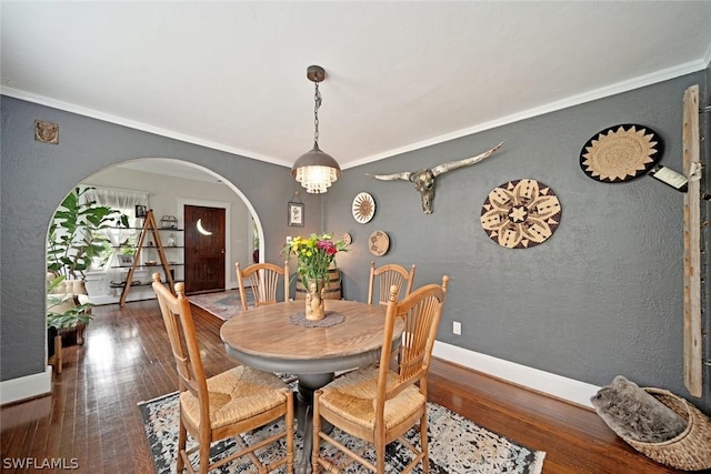 dining room featuring dark hardwood / wood-style floors and crown molding