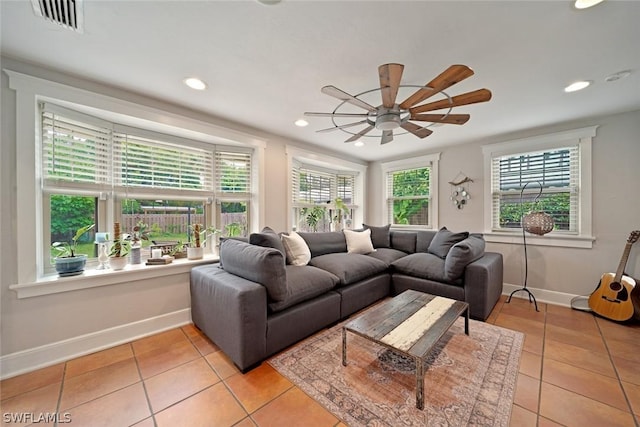 living room featuring light tile patterned floors, ceiling fan, and a healthy amount of sunlight