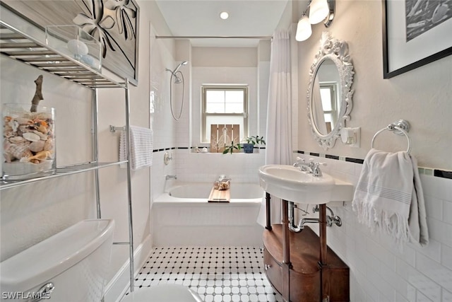 bathroom featuring toilet, tile walls, and shower / bath combo with shower curtain