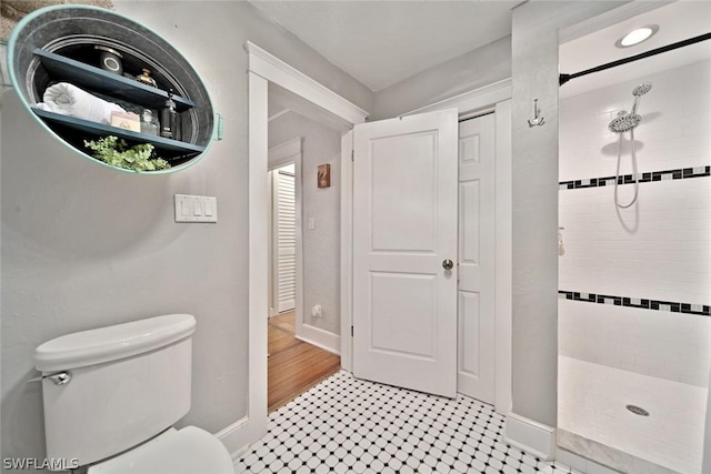 bathroom with toilet and tiled shower