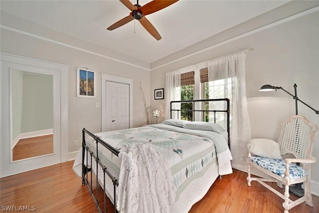 bedroom featuring ceiling fan, wood-type flooring, and a closet