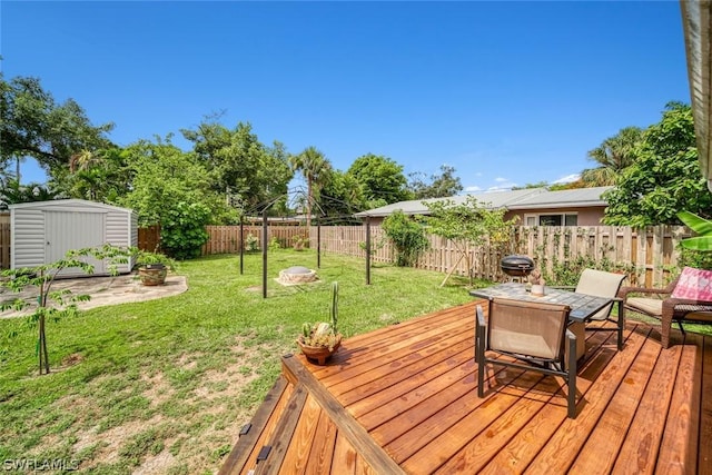 wooden deck with a shed and a lawn