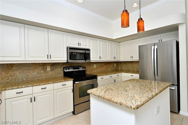 kitchen with white cabinets, decorative light fixtures, a kitchen island, and appliances with stainless steel finishes