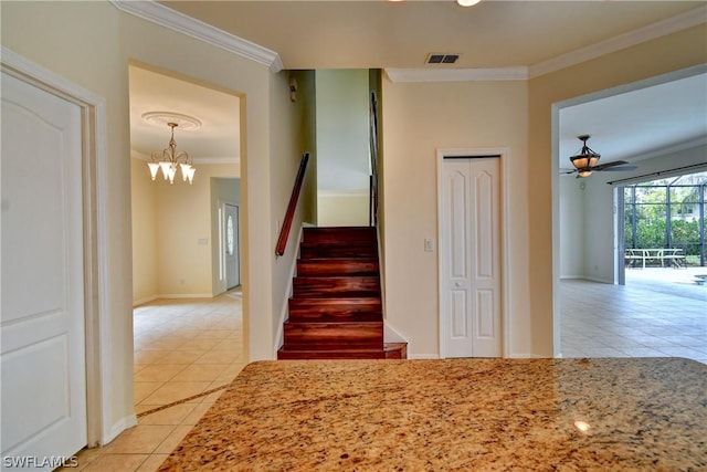 stairs featuring ceiling fan with notable chandelier, tile patterned floors, and crown molding