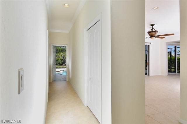 corridor featuring crown molding and light tile patterned flooring