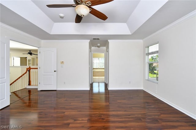 unfurnished room featuring dark hardwood / wood-style floors, ceiling fan, a raised ceiling, and crown molding