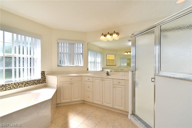 bathroom with vanity, independent shower and bath, and a wealth of natural light