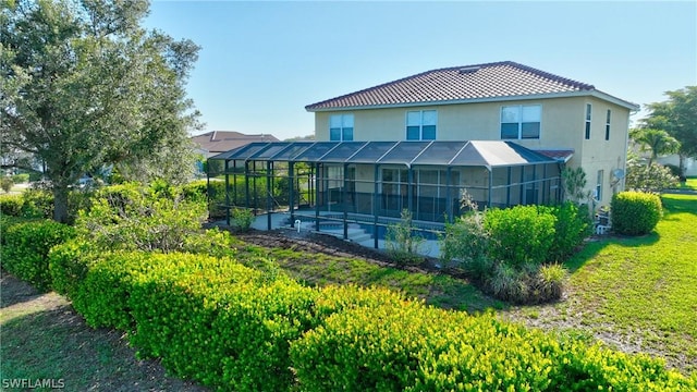 back of property featuring a lanai, a yard, and a pool