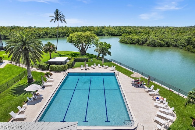 view of pool featuring a lawn, a patio area, and a water view