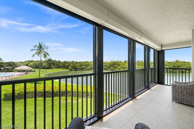 unfurnished sunroom featuring a water view and plenty of natural light