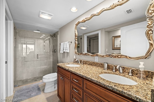 bathroom with tile patterned flooring, vanity, a shower with shower door, and toilet