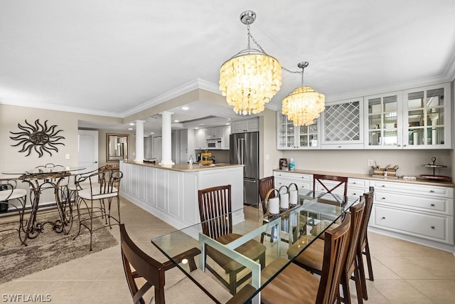 tiled dining area featuring crown molding and an inviting chandelier