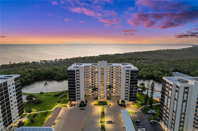 aerial view at dusk featuring a water view