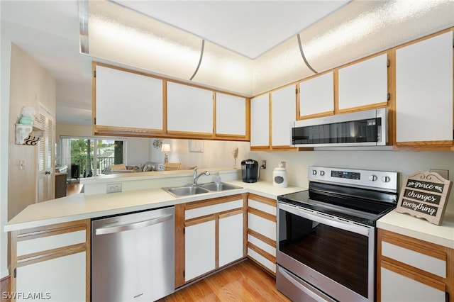 kitchen featuring sink, stainless steel appliances, and white cabinetry