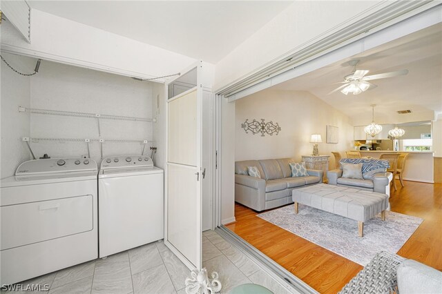 washroom with hookup for a washing machine, separate washer and dryer, light tile floors, and ceiling fan with notable chandelier